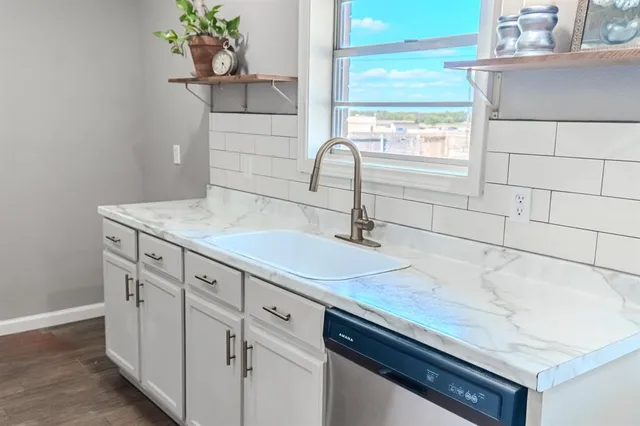 a kitchen with stainless steel appliances kitchen island granite countertop a stove and a sink