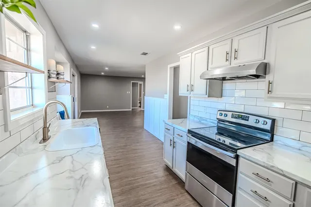 a view of a big room with wooden floor and windows