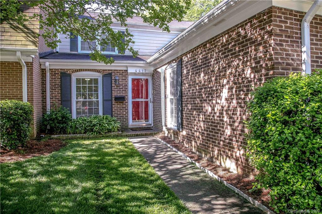 4417 Simsbury Road Charlotte, NC 28226 - Photo 1 of 42 a view of a brick house with a large windows plants and large trees