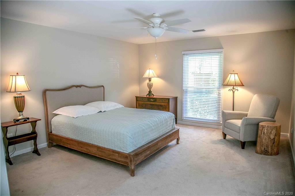 4417 Simsbury Road Charlotte, NC 28226 - Photo 14 of 42 a spacious bedroom with a bed and a chandelier