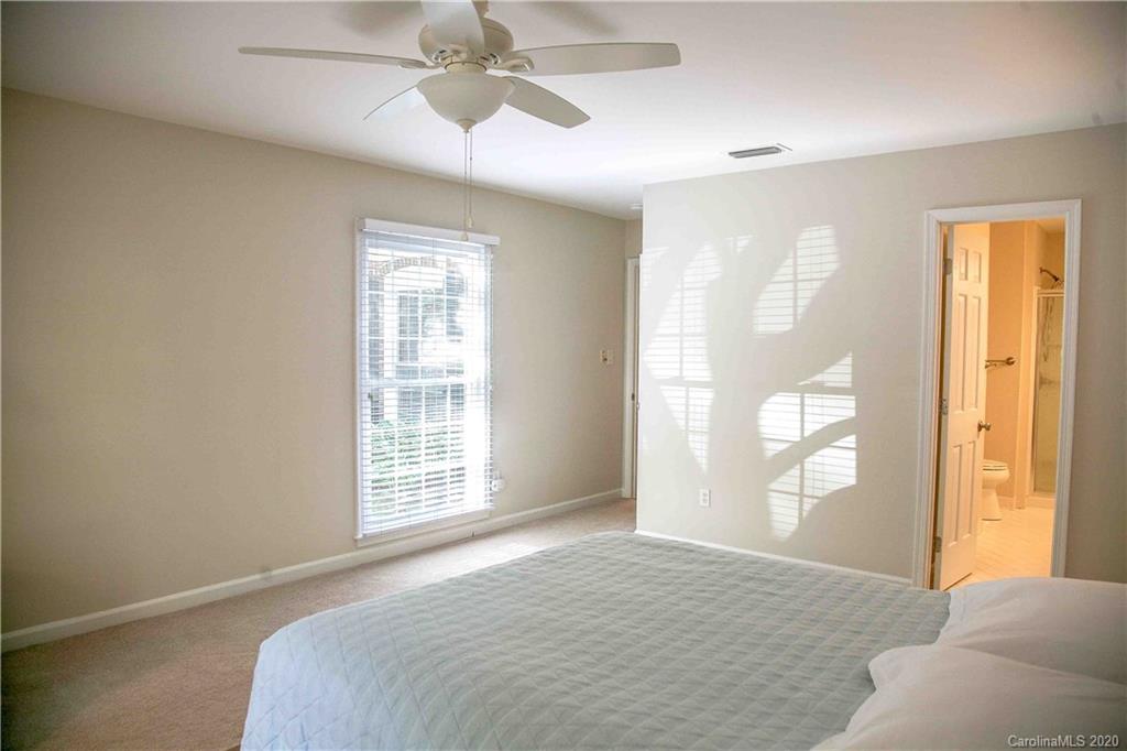 4417 Simsbury Road Charlotte, NC 28226 - Photo 15 of 42 a bedroom with a large bed and a chandelier