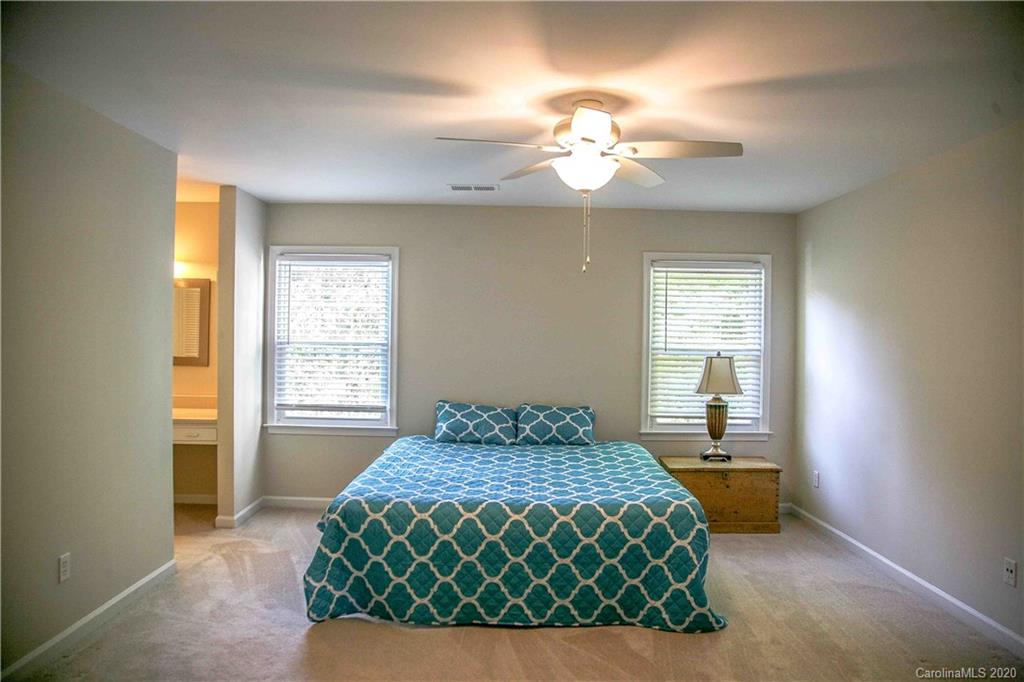4417 Simsbury Road Charlotte, NC 28226 - Photo 18 of 42 a bedroom with a bed and a chandelier