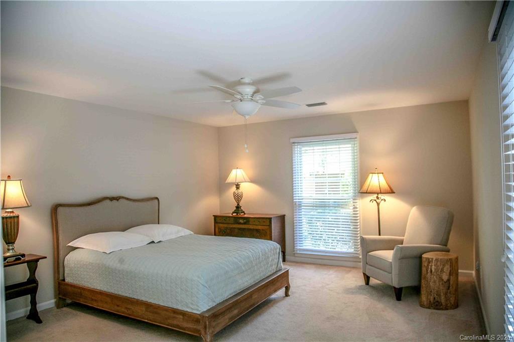 4417 Simsbury Road Charlotte, NC 28226 - Photo 32 of 42 a bedroom with a bed and a lamp