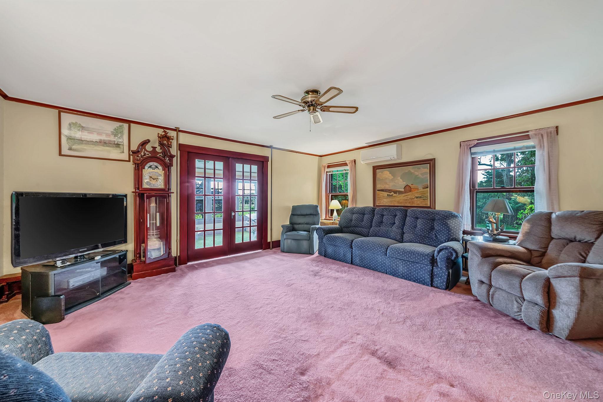 1055 Oregon Road Mattituck, NY 11952 - Photo 15 of 33 Spacious interior room featuring light-colored walls, wood trim, and a ceiling fan. French Doors to Parlor