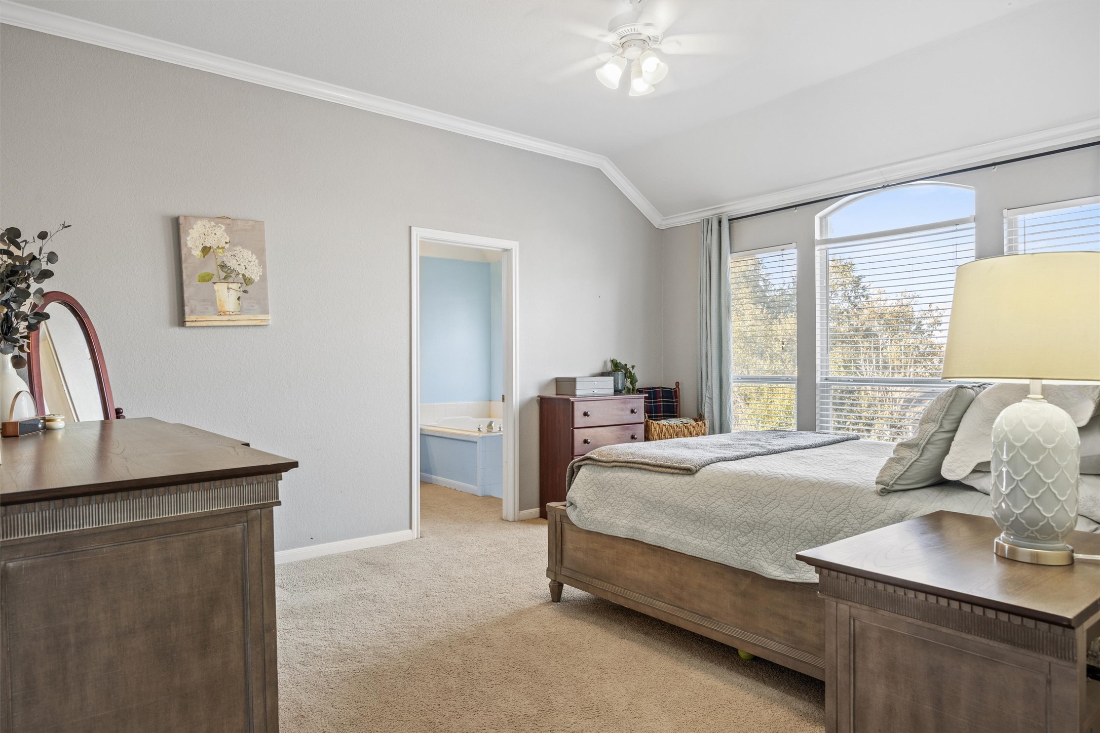 122 Summers Green Georgetown, TX 78633 - Photo 3 of 22 Bedroom featuring light carpet, ornamental molding, vaulted ceiling, a ceiling fan, and connected bathroom