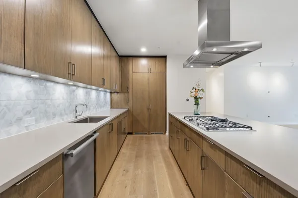 a kitchen with stainless steel appliances granite countertop a sink a stove and a wooden floors