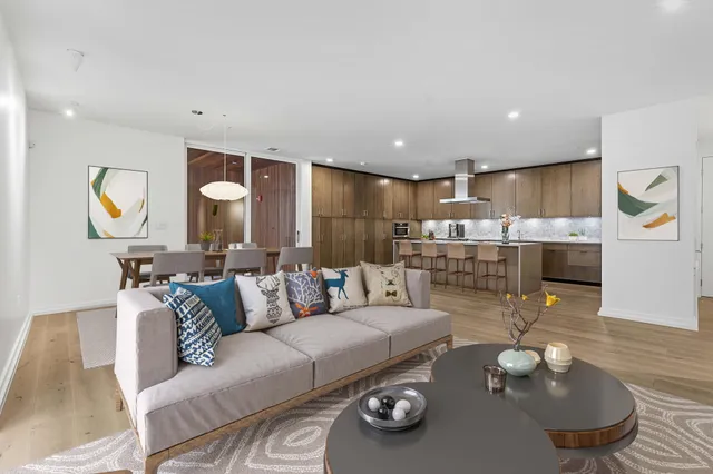a living room with furniture kitchen view and a chandelier