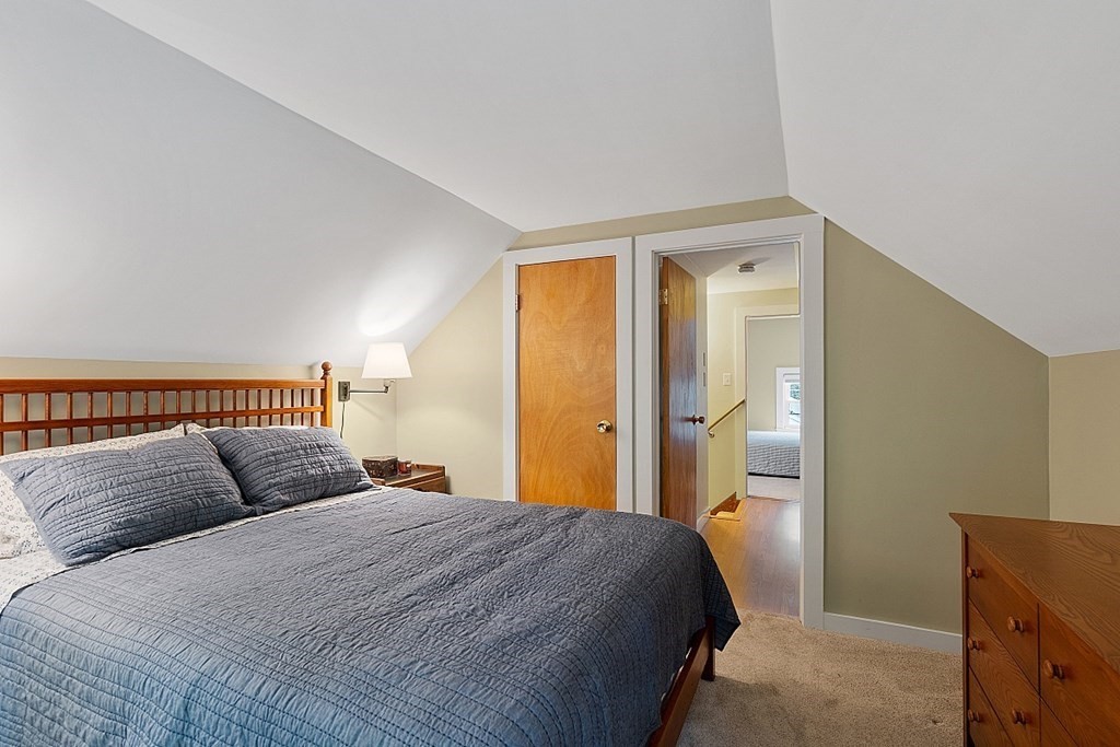 187 Red Acre Road Stow, MA 01775 - Photo 15 of 27 a bedroom with a large bed and wooden floor