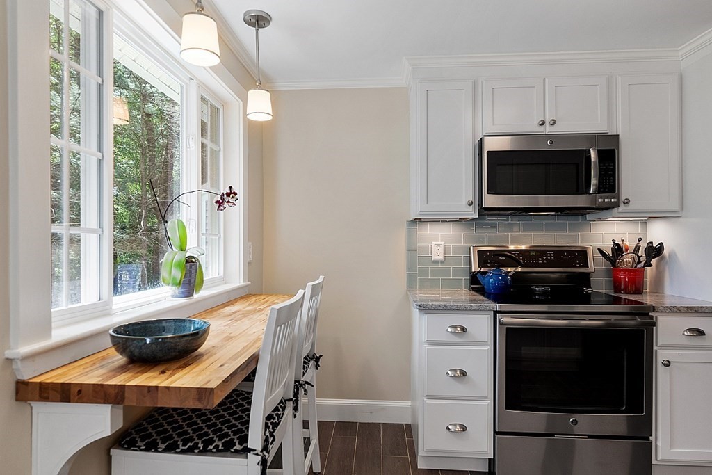 187 Red Acre Road Stow, MA 01775 - Photo 9 of 27 a kitchen with stainless steel appliances a stove a microwave and cabinets