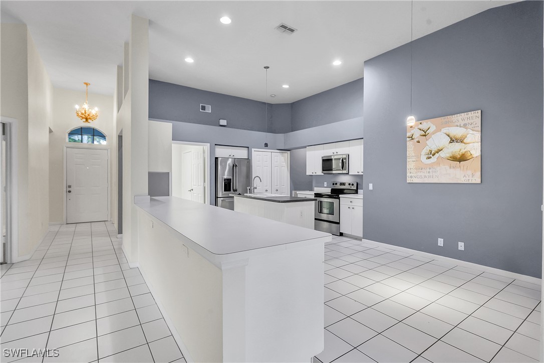 22203 Seashore Circle Estero, FL 33928 - Photo 19 of 45 a large white kitchen with a cabinetry and stainless steel appliances