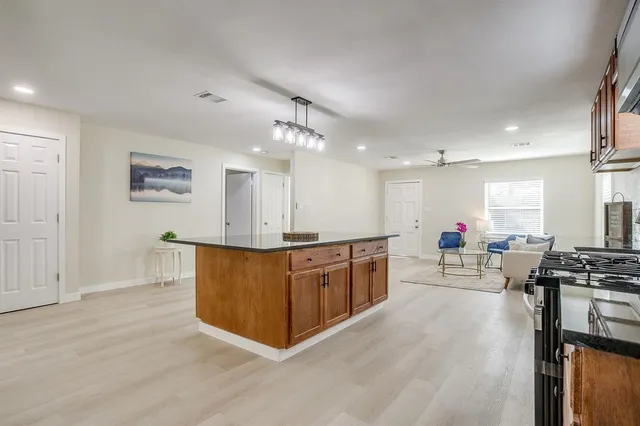 a large kitchen with stainless steel appliances lots of counter space and wooden floor