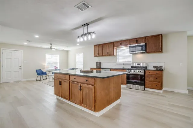 a kitchen with stainless steel appliances granite countertop a stove and a microwave
