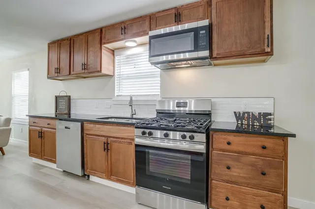 a kitchen with granite countertop cabinets stainless steel appliances and wooden cabinets