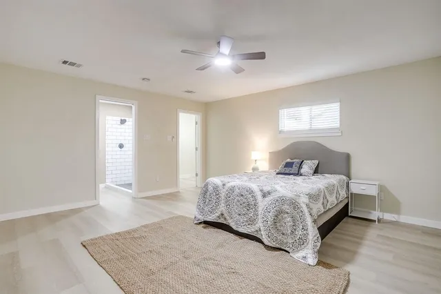 a bedroom with a large bed and a chandelier