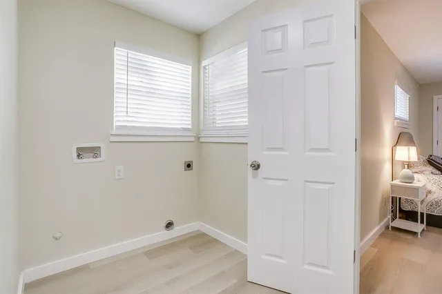 a bed sitting in a bedroom next to a window and a chandelier