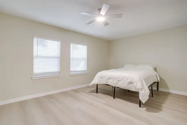 a bedroom with a bed and a ceiling fan