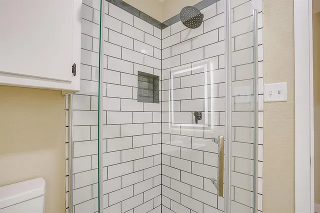 a bathroom with a granite countertop sink and a window