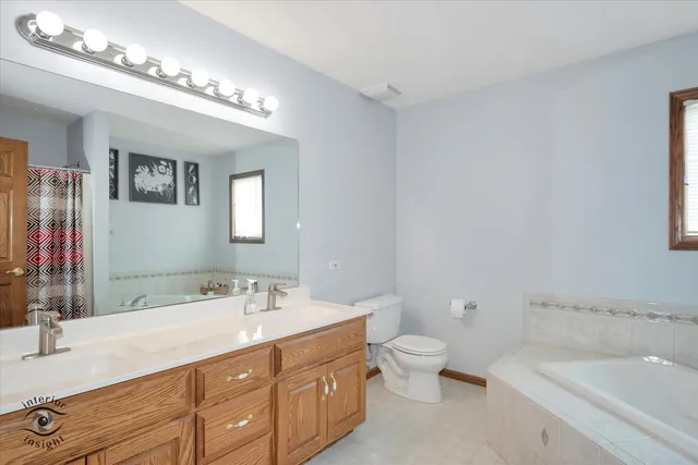 a bathroom with a sink a toilet a mirror and shower