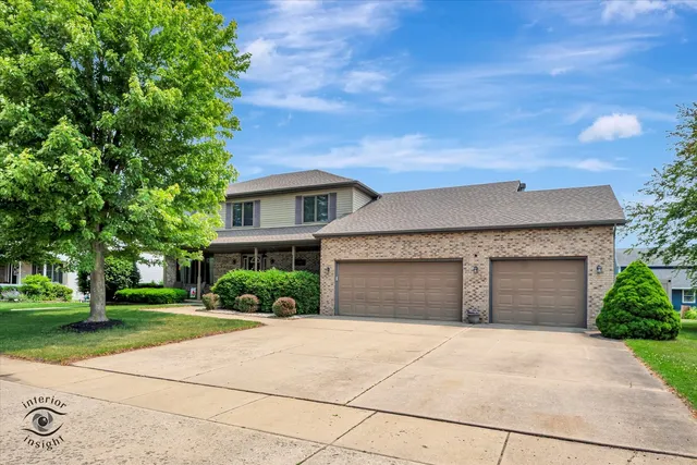 front view of a house with a yard and an trees