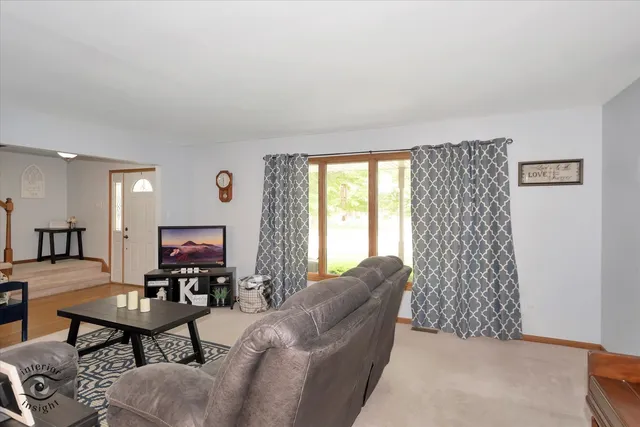 a living room with furniture a flat screen tv and a window