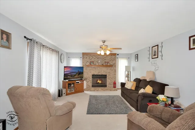 a living room with furniture a fireplace and a window