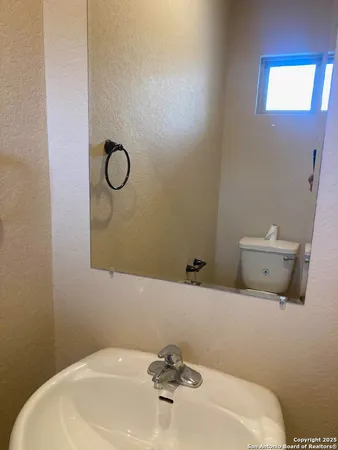 a bathroom with a sink a toilet and mirror