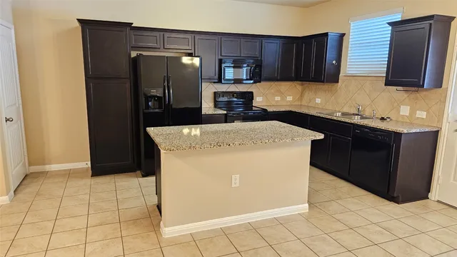 a kitchen with stainless steel appliances a refrigerator sink and cabinets