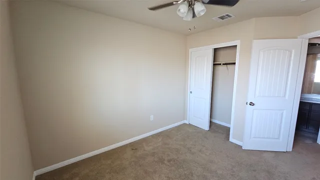 an empty room with a chandelier fan
