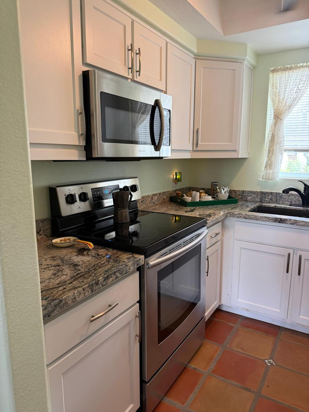 1825 West Ray Road, Unit 1012 Chandler, AZ 85224 - Photo 18 of 34 a kitchen with granite countertop white cabinets stainless steel appliances and a sink