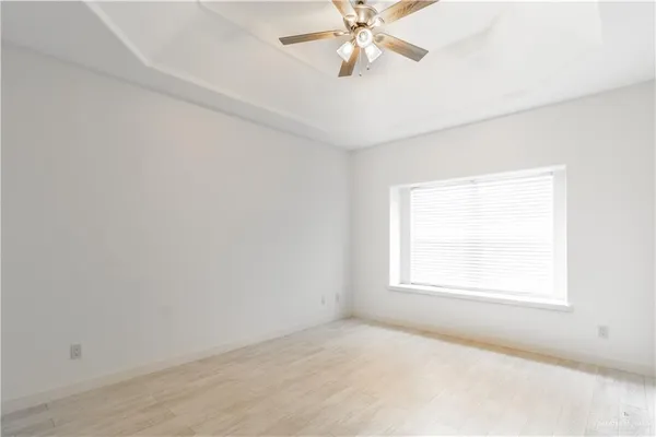 an empty room with windows and fan