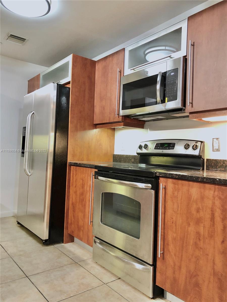 a kitchen with stainless steel appliances granite countertop a stove microwave and refrigerator