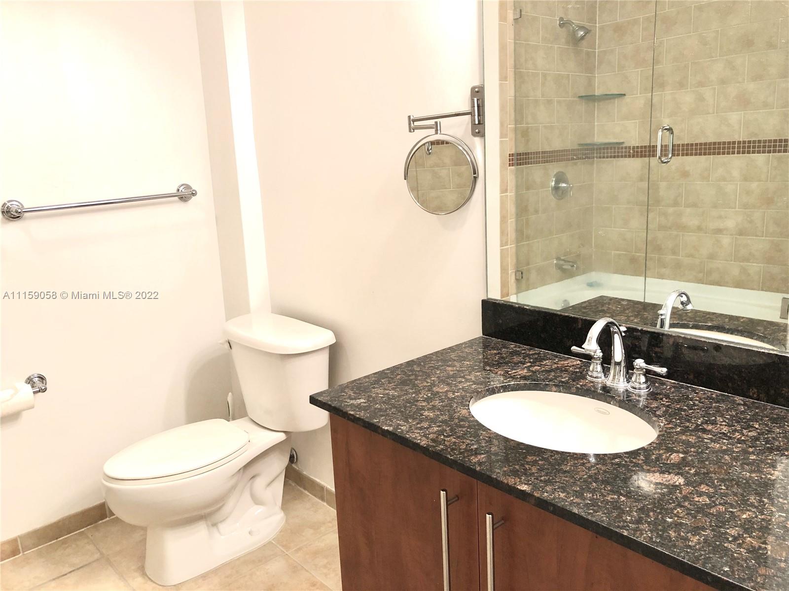 7371 Southwest 90th Street, Unit TH106S Miami, FL 33156 - Photo 13 of 25 a bathroom with a granite countertop sink toilet and shower