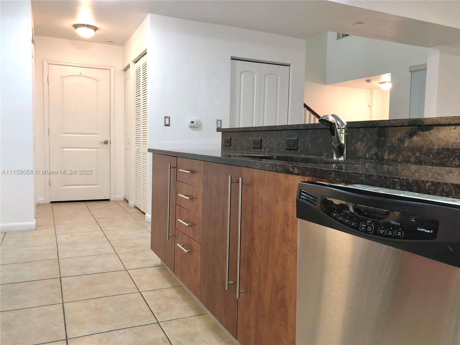 7371 Southwest 90th Street, Unit TH106S Miami, FL 33156 - Photo 3 of 25 a kitchen with stainless steel appliances a sink stove and cabinets