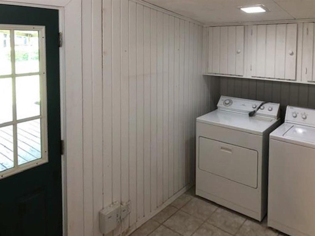 602 West 3rd Street Justin, TX 76247 - Photo 17 of 22 Utility area featuring vertical paneling, integrated upper cabinetry, and tile flooring