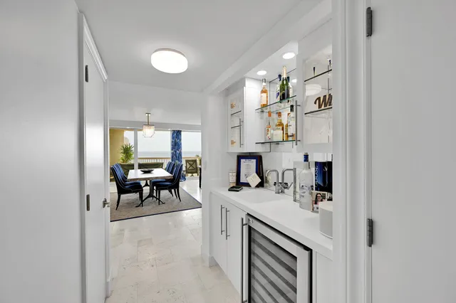 a kitchen that has a sink and chairs in it