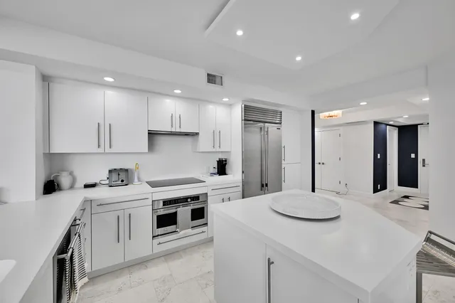 a large white kitchen with sink stove and refrigerator