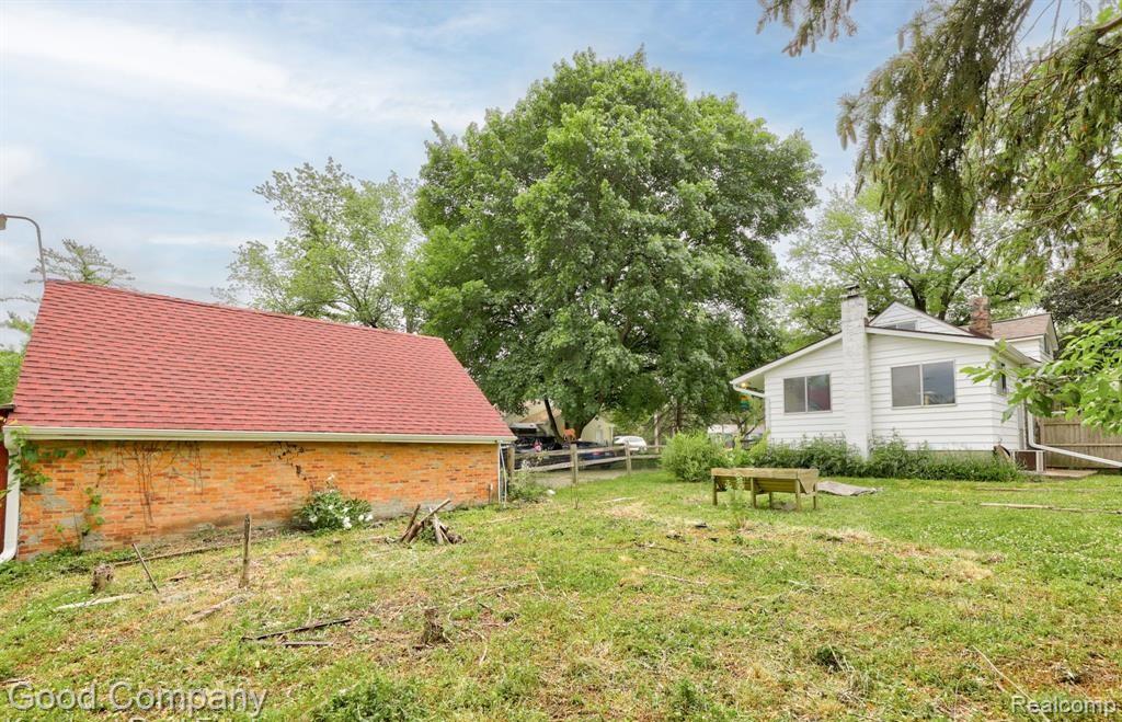 836 West Silver Lake Road Fenton, MI 48430 - Photo 59 of 62 Detached brick structure with a red roof, white siding residence with a chimney, and expansive green space