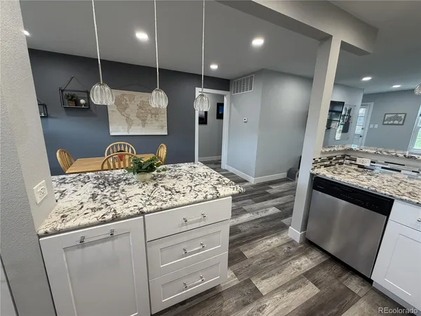 a kitchen with kitchen island granite countertop stainless steel appliances and wooden cabinets