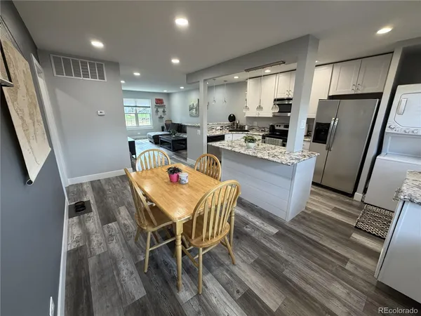 a dining room with stainless steel appliances wooden floors and view
