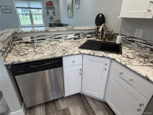 a kitchen with granite countertop a sink and cabinets