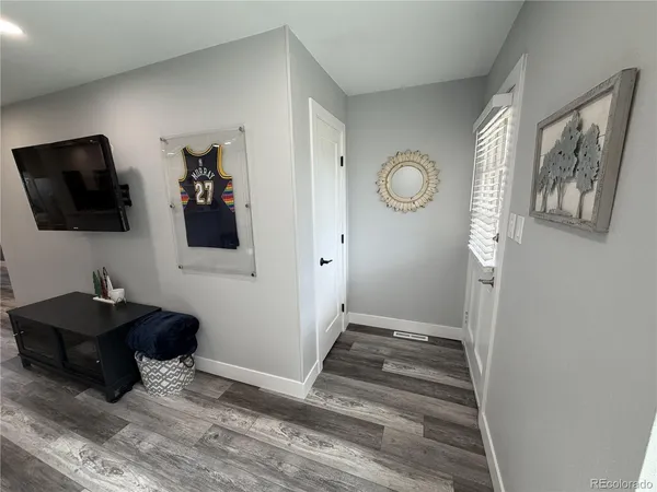 a view of a hallway with cabinet and a flat screen tv
