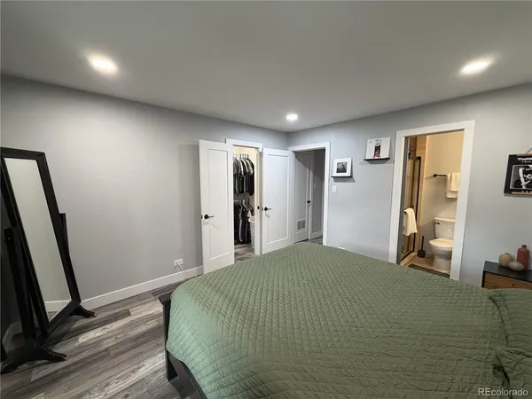 a bedroom with a bed and a large mirror