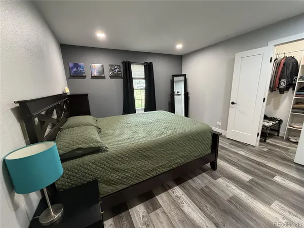 a bedroom with a bed a mirror and furniture