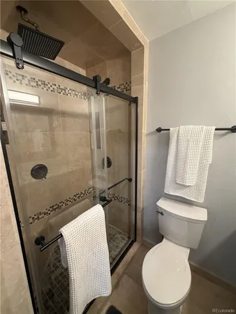 a bathroom with a toilet and a shower