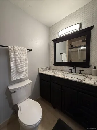 a bathroom with a toilet sink double vanity and mirror