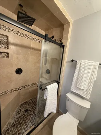 a bathroom with a toilet and a shower