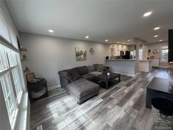 a living room with furniture and a wooden floor