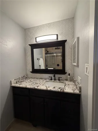 a bathroom with a granite countertop sink and a mirror