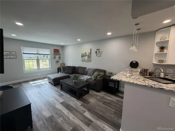 a living room with a couch wooden floor and a window