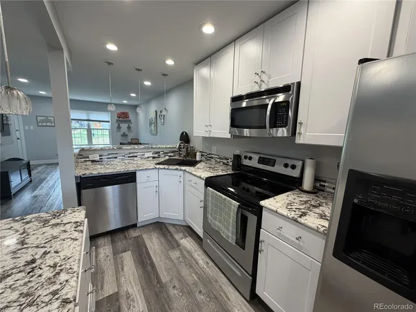 a kitchen with stainless steel appliances granite countertop a stove sink and microwave